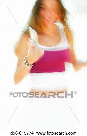 Blurred image of a young girl holding a cell phone View Large Photo Image Picture - Blurred image of a young girl holding a cell phone. Fotosearch