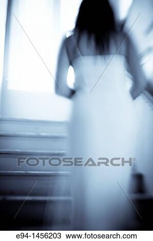 Blurry back view of a woman in a white dress walking up a stairway, indoors View Large Photo Image Stock Image - Blurry back view of a woman in a white dress walking up a stairway, indoors. Fotosearch