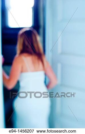 Blurry Back View Of A Woman In A White Dress Going In A Doorway Inside Of A Home Stock Photo E94 1456207 Fotosearch