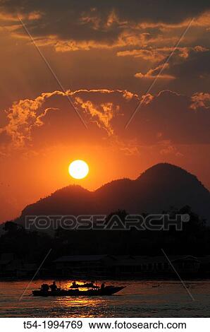 Boat at sunset at River Kwai View Large Photo Image Stock Photo - Boat at sunset at River Kwai. Fotosearch