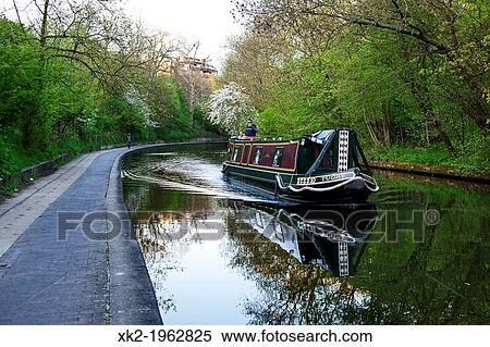 Boat navigating along Regents canal, near Regents Park, London, UK View Large Photo Image Stock Photography - Boat navigating along Regents canal, near Regents Park, London, UK. Fotosearch