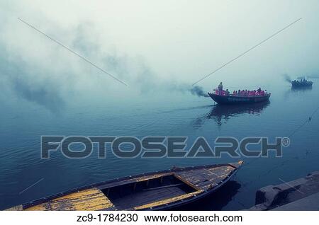 Boats full of indian tourists sailing over Ganges river in a misty morning Varanasi, India View Large Photo Image Stock Image - Boats full of indian tourists sailing over Ganges river in a misty morning Varanasi, India. Fotosearch
