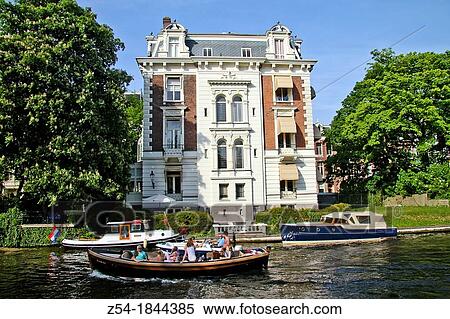 Boats in front of an old town house on the Stadhouderskade, Amsterdam, Holland View Large Photo Image Stock Photography - Boats in front of an old town house on the Stadhouderskade, Amsterdam, Holland. Fotosearch