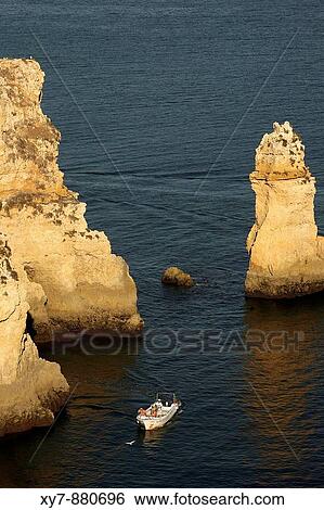 Boats pass through seastacks at Ponta De Piedade near Lagos in the Algarve, Portugal View Large Photo Image Stock Photograph - Boats pass through seastacks at Ponta De Piedade near Lagos in the Algarve, Portugal. Fotosearch