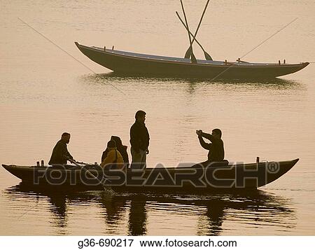 Stock Photo - Boats with pilgrims and tourists at dawn in Varanasi, India, a sacred Hindu pilgrimage site.. Fotosearch