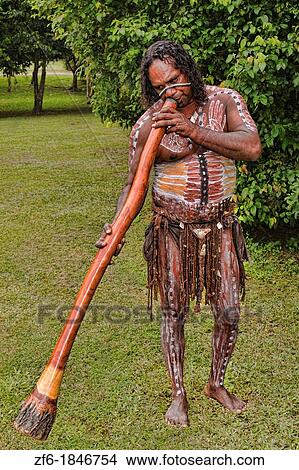 Picture - Body Painted Tjappukai Aboriginal native with Didgeeridoo in Cairns Australia Queensland. Fotosearch