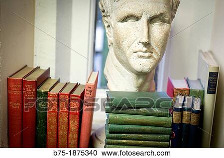 Stock Image - bookcase with group of books and sculpture of a head. Fotosearch