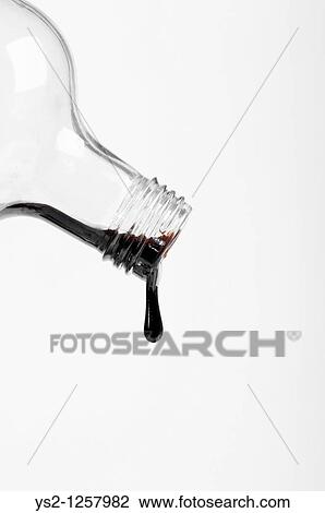 Bottle with black substance dripping View Large Photo Image Stock Image - Bottle with black substance dripping. Fotosearch