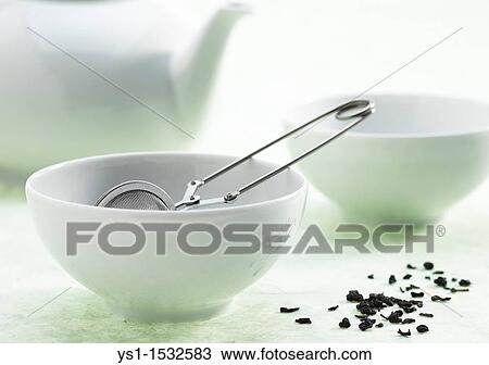 Stock Image - Bowl of green tea, infusion against white background. Fotosearch
