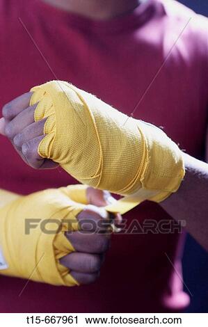 Stock Image - Boxer wrapping his hands in preparation for a fight. Fotosearch