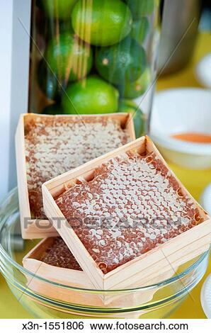 Boxes of honeycomb on display in front of glass vase of limes View Large Photo Image Stock Photograph - Boxes of honeycomb on display in front of glass vase of limes. Fotosearch