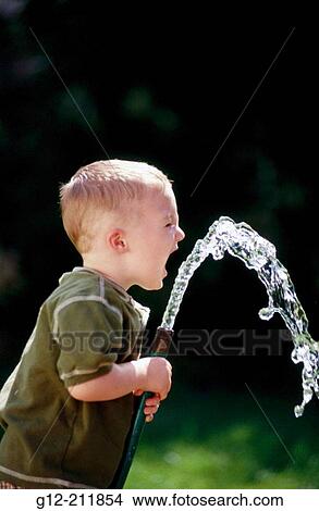 Boy (2 yrs. playing with water hose. Idaho. USA View Large Photo Image Picture - Boy (2 yrs. playing with water hose. Idaho. USA. Fotosearch