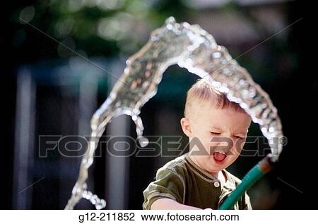 Boy (2 yrs. ) playing with water hose. Idaho. USA View Large Photo Image Stock Image - Boy (2 yrs. ) playing with water hose. Idaho. USA. Fotosearch