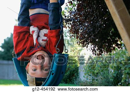 Boy, 5, hanging upside down looking at camera. View Large Photo Image Stock Image - Boy, 5, hanging upside down looking at camera.. Fotosearch