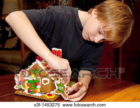Boy age 10 concentrating on decorating Christmas gingerbread house St Paul Minnesota USA View Large Photo Image Stock Photography - Boy age 10 concentrating on decorating Christmas gingerbread house St Paul Minnesota USA. Fotosearch