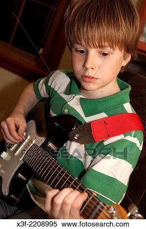 Stock Photography - Boy age 11 playing guitar at home. St Paul Minnesota MN USA.. Fotosearch