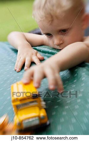 Boy age 2 playing with schoolbus toy, soft-focus, summer, Poughkeepsie, New York, USA View Large Photo Image Stock Image - Boy age 2 playing with schoolbus toy, soft-focus, summer, Poughkeepsie, New York, USA. Fotosearch