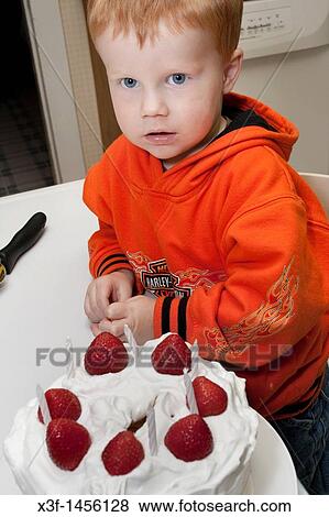 Boy age 3 inspecting a strawberry topped birthday cake Clitherall Minnesota MN USA View Large Photo Image Stock Photo - Boy age 3 inspecting a strawberry topped birthday cake Clitherall Minnesota MN USA. Fotosearch