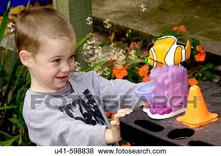 Boy age 4 playing with bubble machine at party. View Large Photo Image Stock Photo - Boy age 4 playing with bubble machine at party.. Fotosearch