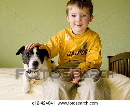 Boy, age 4, siting on bed with his Jack Russell Terrier pet dog View Large Photo Image Stock Image - Boy, age 4, siting on bed with his Jack Russell Terrier pet dog. Fotosearch