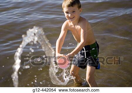 Boy, age 5, throwing water at photographer in Payette Lake. McCall, Idaho. USA View Large Photo Image Picture - Boy, age 5, throwing water at photographer in Payette Lake. McCall, Idaho. USA. Fotosearch