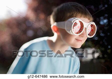 Stock Photograph - Boy, age 7, wearing big sunglasses.. Fotosearch