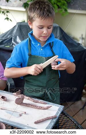 Boy age 8 modeling clay in backyard art group. St Paul Minnesota MN USA. View Large Photo Image Stock Image - Boy age 8 modeling clay in backyard art group. St Paul Minnesota MN USA.. Fotosearch