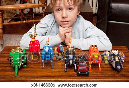 Stock Photography - Boy age 8 pondering his animal transformers St Paul Minnesota MN USA. Fotosearch