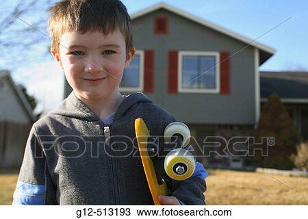 Boy, age five, looking at camera with skateboard in front of home View Large Photo Image Stock Image - Boy, age five, looking at camera with skateboard in front of home. Fotosearch
