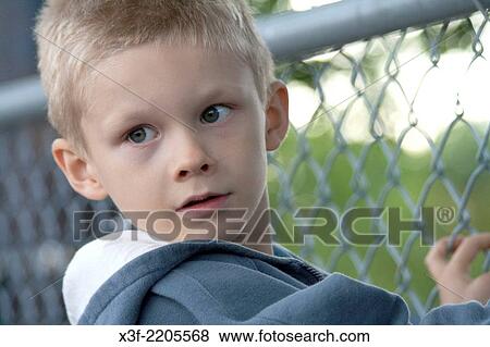 Boy age six looking thru chain link fence at ball game. St Paul Minnesota MN USA. View Large Photo Image Stock Photo - Boy age six looking thru chain link fence at ball game. St Paul Minnesota MN USA.. Fotosearch