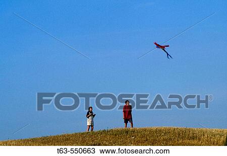 boy and girl flying a kite together View Large Photo Image Stock Image - boy and girl flying a kite together. Fotosearch