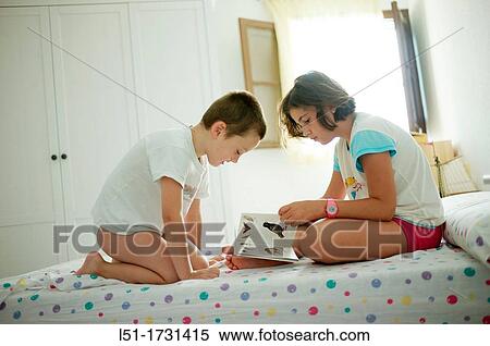 boy and girl on a bedroom reading a book, Ludiente, Castell? n, Spain View Large Photo Image Stock Photography - boy and girl on a bedroom reading a book, Ludiente, Castell? n, Spain. Fotosearch