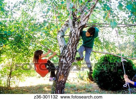 Stock Image - Boy and girl on tree. Fotosearch