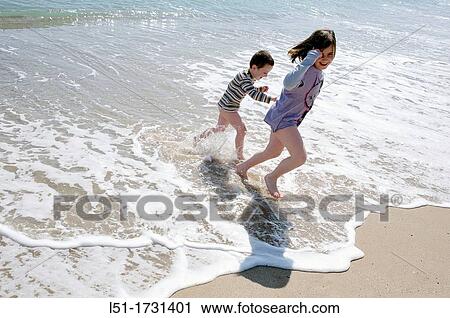 Boy and girl playing in the beach hand in hand, El Saler beach, Albufera de Valencia Nature reserve, Valencia, Spain View Large Photo Image Stock Image - Boy and girl playing in the beach hand in hand, El Saler beach, Albufera de Valencia Nature reserve, Valencia, Spain. Fotosearch