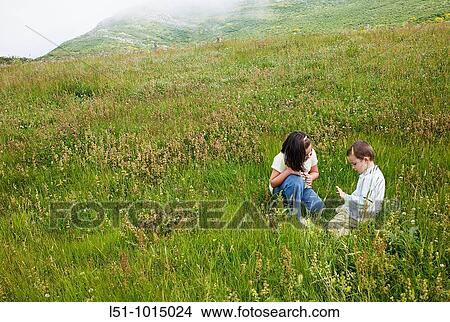 Picture - Boy and girl playing on a meadow in the mountains of Somiedo. Fotosearch