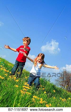 boy and girl playing with bubbles in field of Dandelions, Zuercher Oberland, Zuerich, Switzerland View Large Photo Image Stock Photo - boy and girl playing with bubbles in field of Dandelions, Zuercher Oberland, Zuerich, Switzerland. Fotosearch