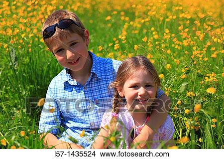 boy and girl sitting in blooming field View Large Photo Image Picture - boy and girl sitting in blooming field. Fotosearch