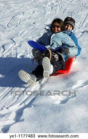 Boy and girl sledding down a snowy hill together. View Large Photo Image Stock Image - Boy and girl sledding down a snowy hill together.. Fotosearch