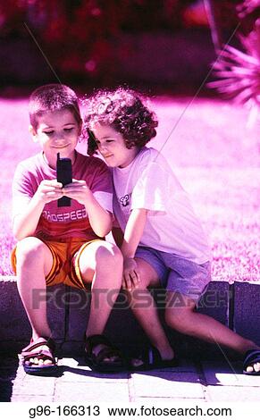 Boy and girl with cell phone View Large Photo Image Stock Image - Boy and girl with cell phone. Fotosearch