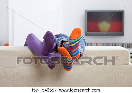 Boy and girls legs sticking up over a sofa View Large Photo Image Stock Photo - Boy and girls legs sticking up over a sofa. Fotosearch