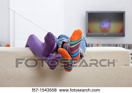 Boy and girls legs sticking up over a sofa View Large Photo Image Stock Photo - Boy and girls legs sticking up over a sofa. Fotosearch