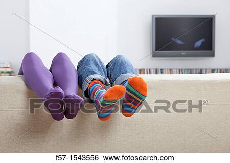 Boy and girls legs sticking up over a sofa View Large Photo Image Stock Photograph - Boy and girls legs sticking up over a sofa. Fotosearch