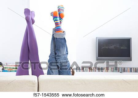 Boy and girls legs sticking up over a sofa View Large Photo Image Stock Photography - Boy and girls legs sticking up over a sofa. Fotosearch