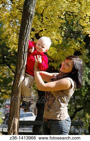 Stock Photograph - Boy and mother having fun at autumn. Fotosearch