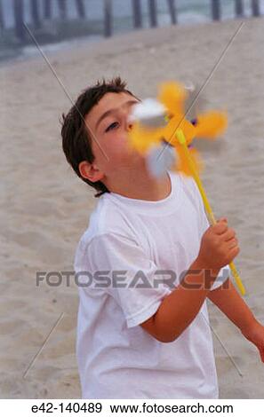 Boy blowing a windmill toy View Large Photo Image Stock Photo - Boy blowing a windmill toy. Fotosearch