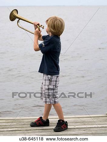 Stock Photo - boy blowing bugle. Albemarle Sound, NC. Fotosearch
