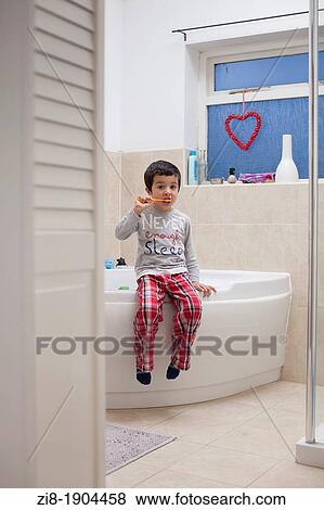 Stock Photo - Boy brushing his teeth in the morning. Fotosearch