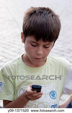 Stock Image - Boy calls with a cellphone, Prague, Czech Republic.. Fotosearch