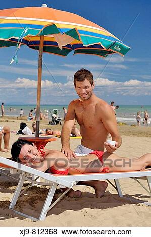 Stock Photo - Boy cream coating on the back of a girl.. Fotosearch