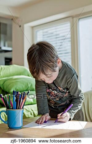 Boy draws with crayons indoor. View Large Photo Image Picture - Boy draws with crayons indoor.. Fotosearch